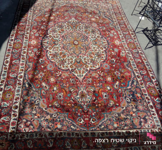שטיח פרסי צבעוני מונח על רצפה בחוץ